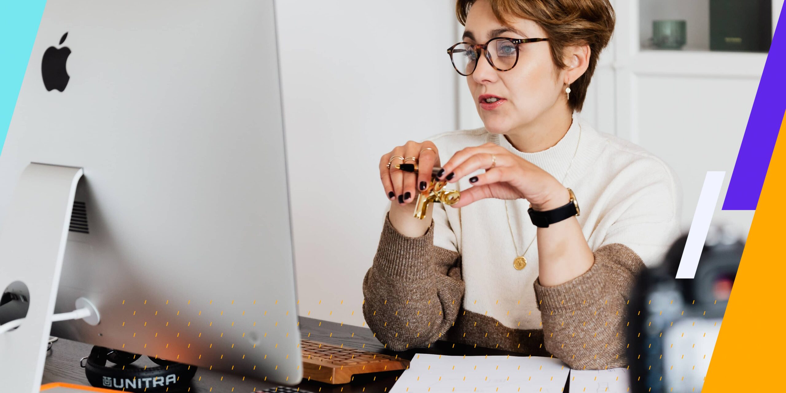 Woman with glasses and a short hair cut looks at iMac